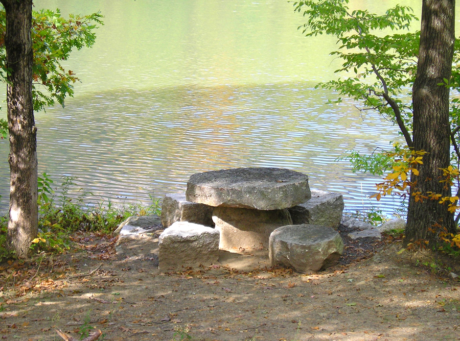 stone table and chairs by stream